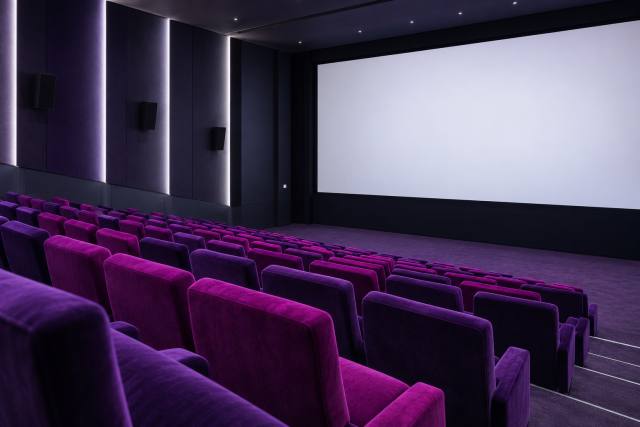 Lilla biografsæder og hvidt lærred i en fiktiv sal; ikke et foto fra filmprisuddelingen. AI-genereret, fotorealistisk temabillede; viser ikke den konkrete begivenhed.