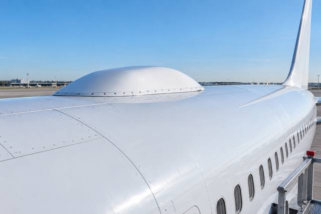 AI-genereret, fotorealistisk temabillede af et fiktivt passagerfly med antennekappe; ikke et easyJet-fly, et Starlink-produktfoto eller dokumentation af installationen.