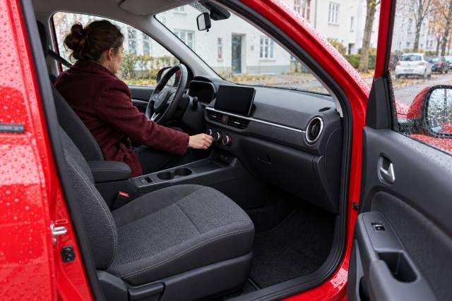 Varmebetjening i en fiktiv rød elbil; ikke en Hyundai Ioniq 3 eller dokumentation af prisændringen. AI-genereret, fotorealistisk temabillede; viser ikke den konkrete begivenhed.