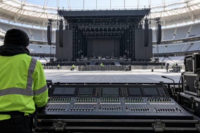 AI-genereret, fotorealistisk temabillede af en fiktiv stadionproduktion med lydpult og tekniker; ikke Jay-Z, SoFi Stadium eller et foto fra Super Bowl-showet.